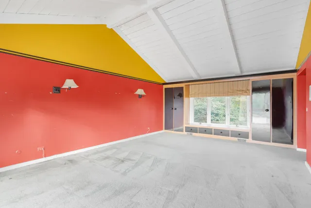 a view of a big room with wooden floor and windows