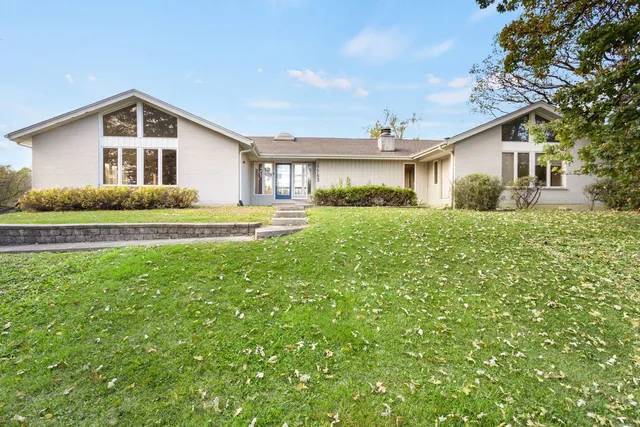 a view of a yard in front of a house with a large tree