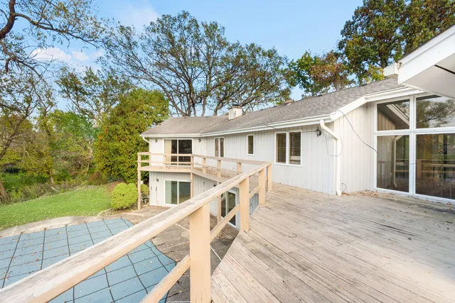 a view of house with roof deck and yard