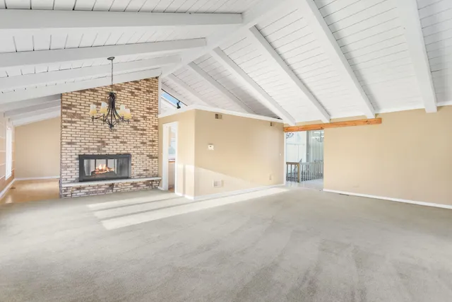 a view of an empty room with a fireplace and a window