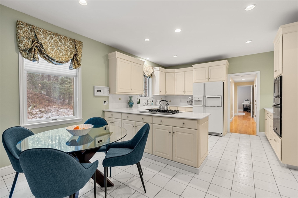 3 Stone Road Boxford, MA 01921 - Photo 13 of 40 a kitchen with a dining table chairs cabinets and stainless steel appliances
