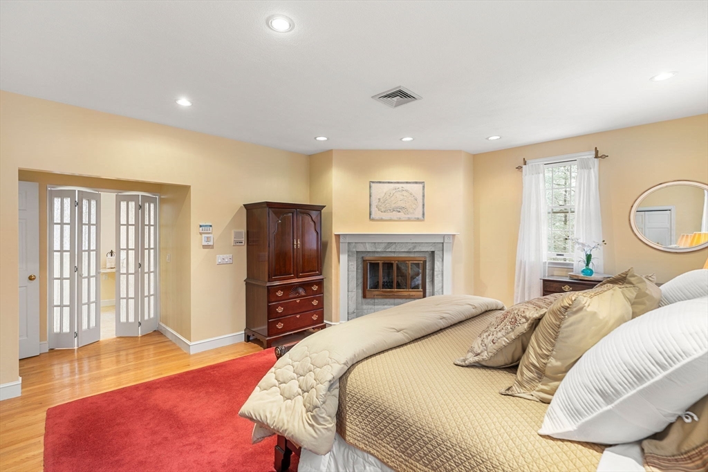 3 Stone Road Boxford, MA 01921 - Photo 19 of 40 a bedroom with a bed and a fireplace