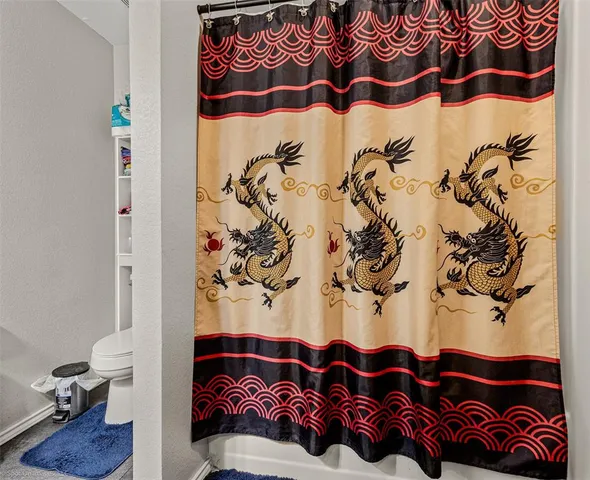 a living room with a couch and a lamp on the wall