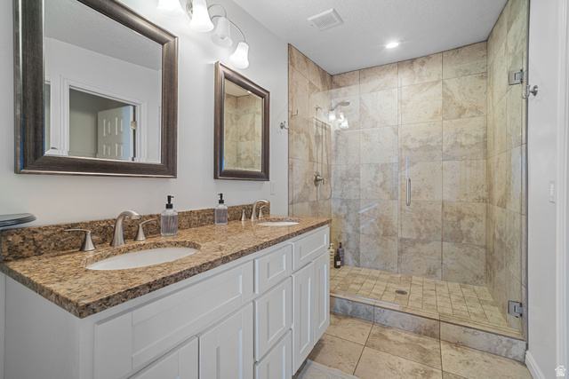 4426 South 3035 East Holladay, UT 84124 - Photo 5 of 49 Full bath featuring a shower stall, double vanity, and light tile patterned floors