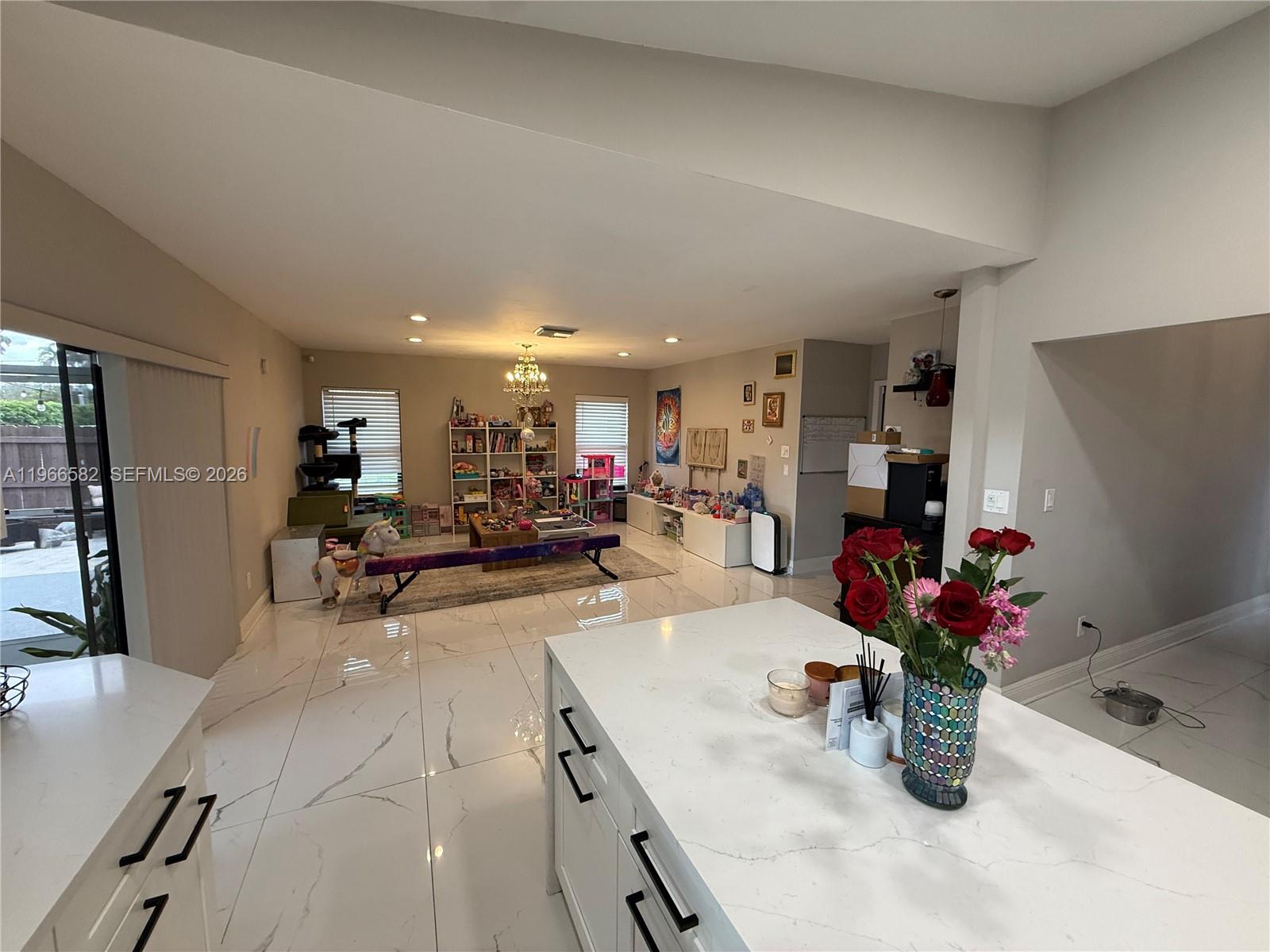 20888 Sugarloaf Lane Boca Raton, FL 33428 - Photo 14 of 25 a kitchen with a sink dining table and chairs