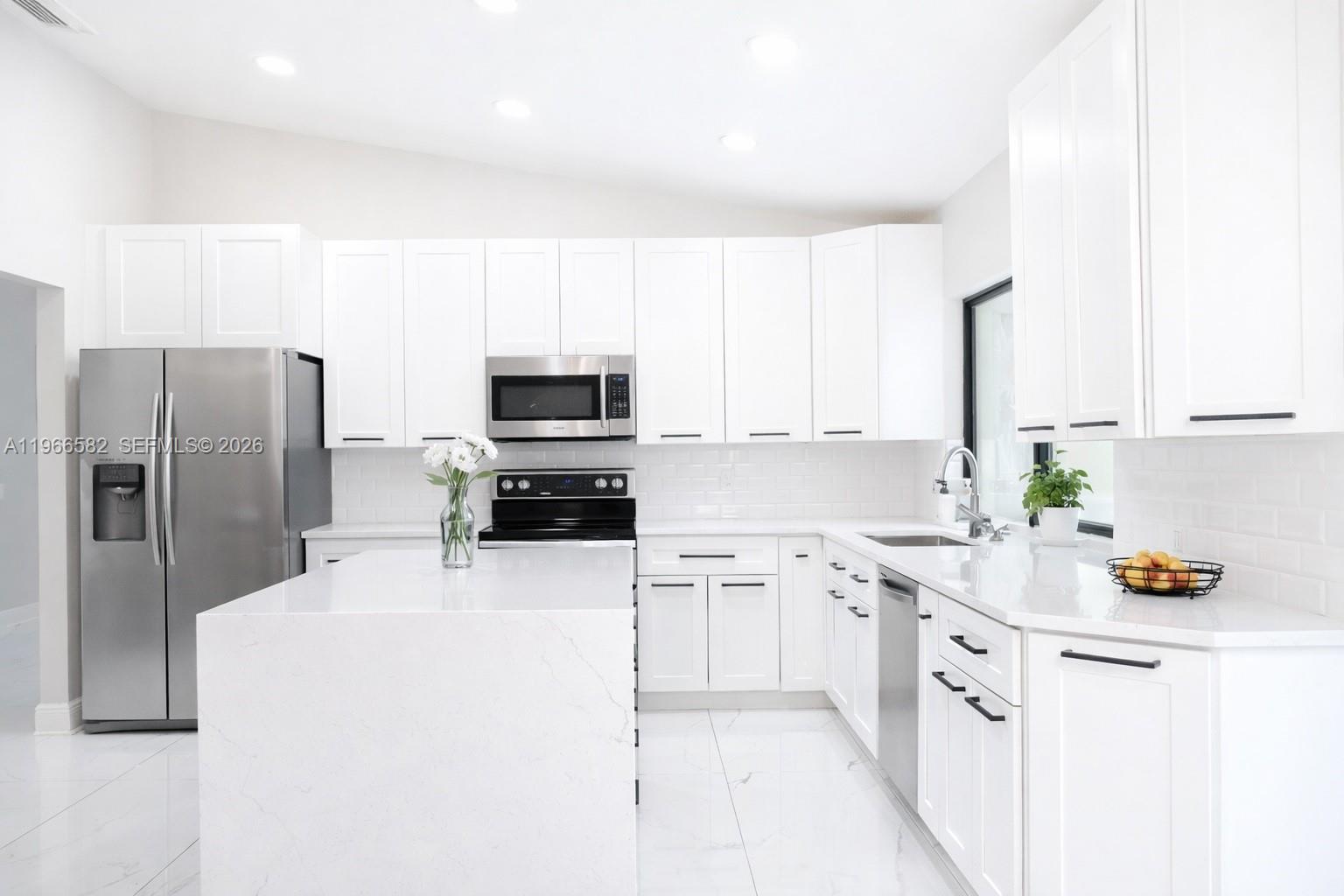 20888 Sugarloaf Lane Boca Raton, FL 33428 - Photo 17 of 25 a kitchen with a sink a refrigerator a microwave and cabinets