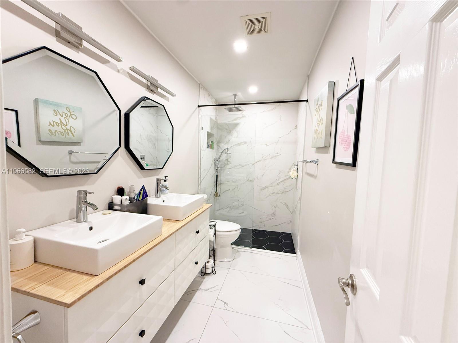 20888 Sugarloaf Lane Boca Raton, FL 33428 - Photo 6 of 25 a bathroom with a sink mirror toilet and shower