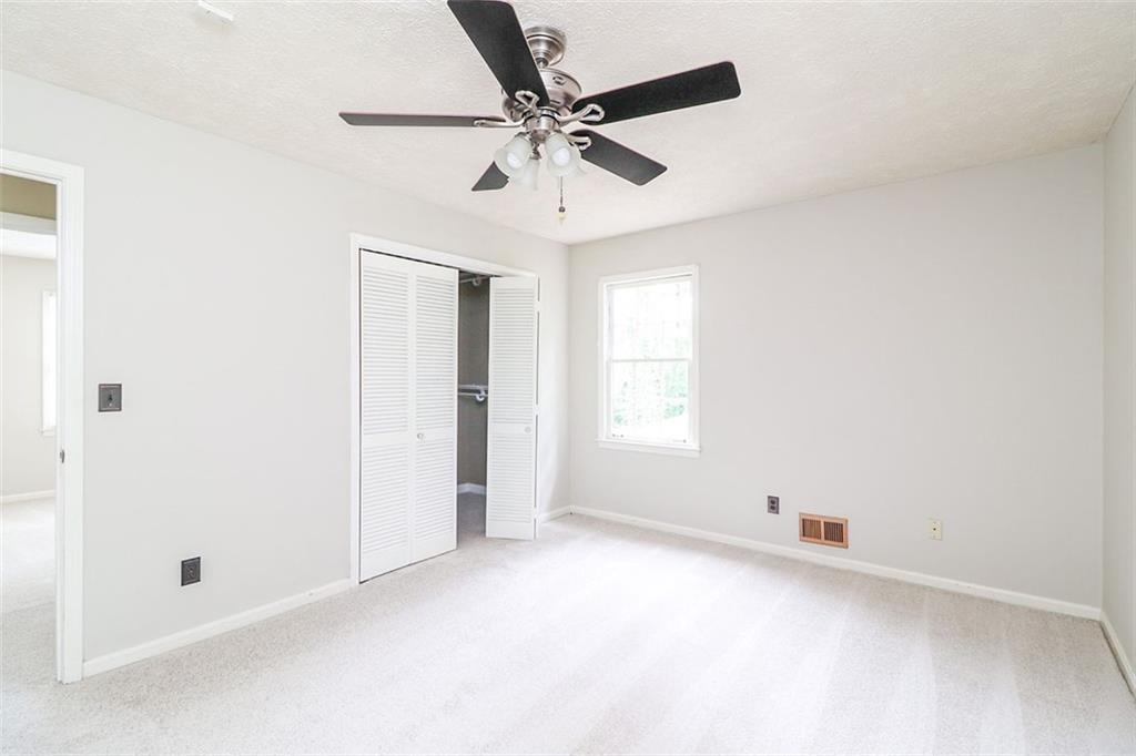 1291 Stephens Street Southwest Lilburn, GA 30047 - Photo 22 of 22 an empty room with a window and a fan