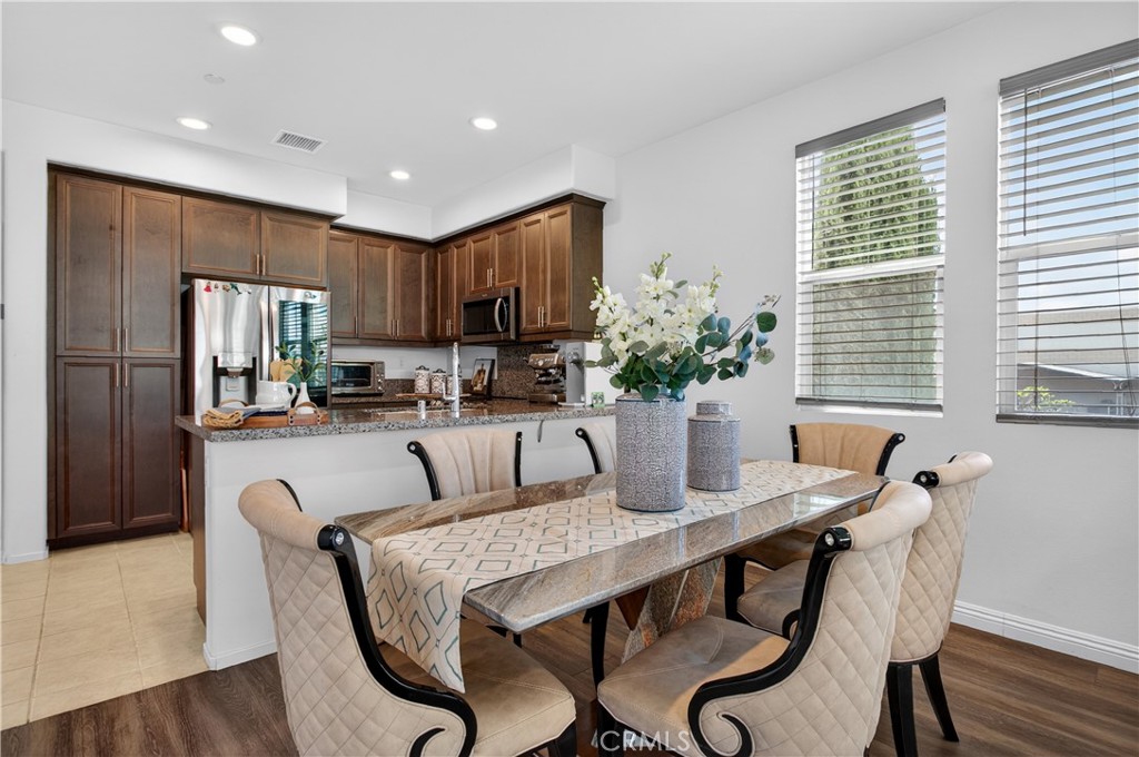 5796 Spring Street Buena Park, CA 90621 - Photo 12 of 33 a kitchen with a table chairs refrigerator and microwave