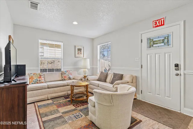 a living room with furniture a window and a flat screen tv