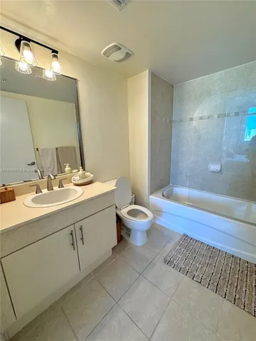 a bathroom with a double vanity sink toilet and mirror