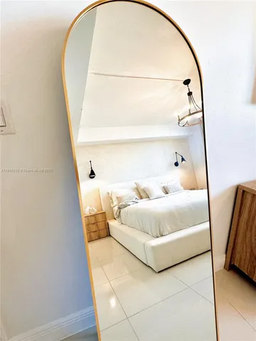 a bedroom with a bed and a mirror