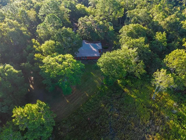 an aerial view of a house with a yard and garden