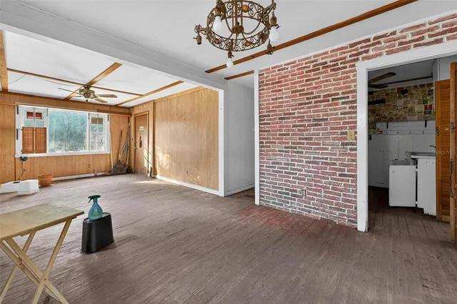 a view of a hallway with a dining room and chandelier