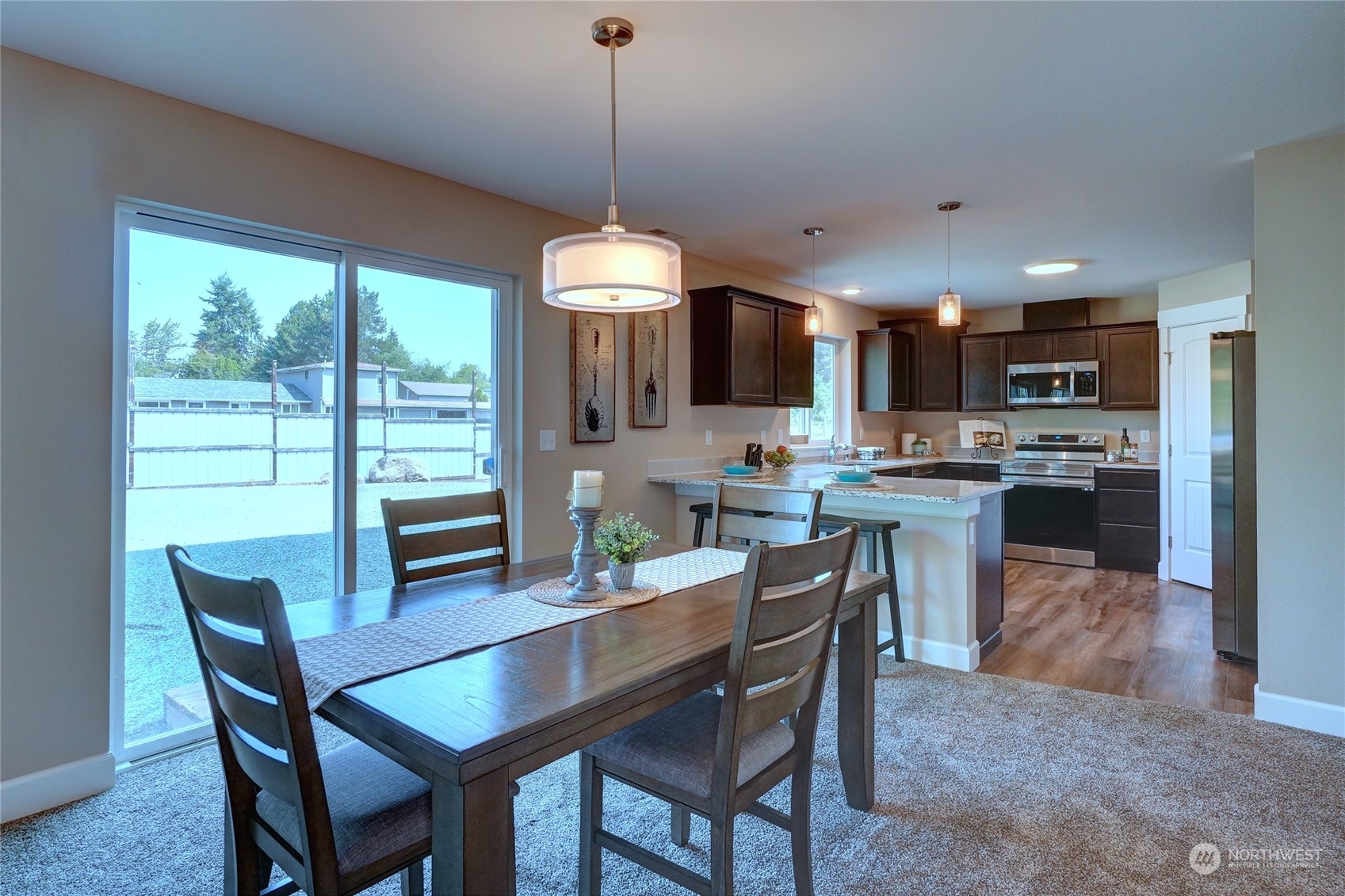 10705 36th Street East Edgewood, WA 98372 - Photo 11 of 40 a dining room with stainless steel appliances granite countertop a table chairs and a view of kitchen