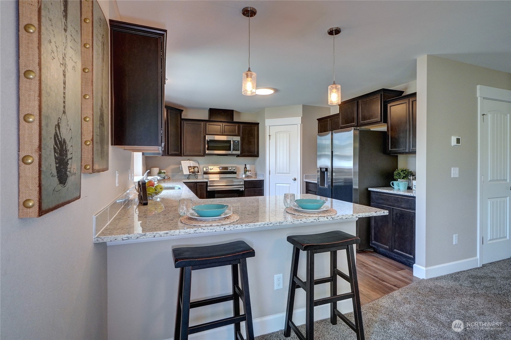 10705 36th Street East Edgewood, WA 98372 - Photo 12 of 40 a kitchen with stainless steel appliances granite countertop a stove top oven a refrigerator a sink and a granite counter tops