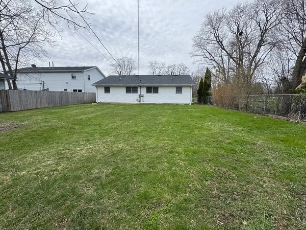 a view of a big house with a big yard and large tree