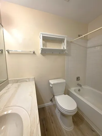 a white toilet sitting next to a bathroom sink and tub