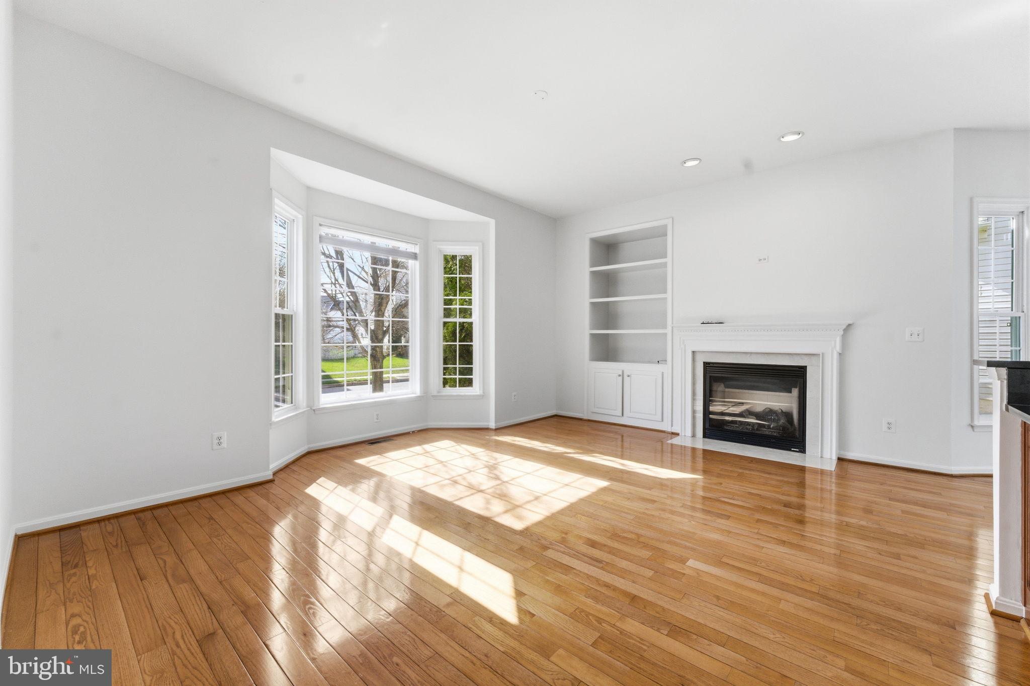 43358 Fullerton Street Ashburn, VA 20147 - Photo 12 of 54 a view of an empty room with wooden floor fireplace and a window
