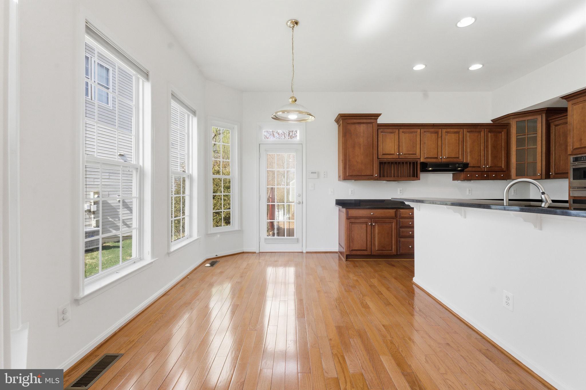 43358 Fullerton Street Ashburn, VA 20147 - Photo 16 of 54 a kitchen with kitchen island granite countertop a stove a sink and a wooden floors