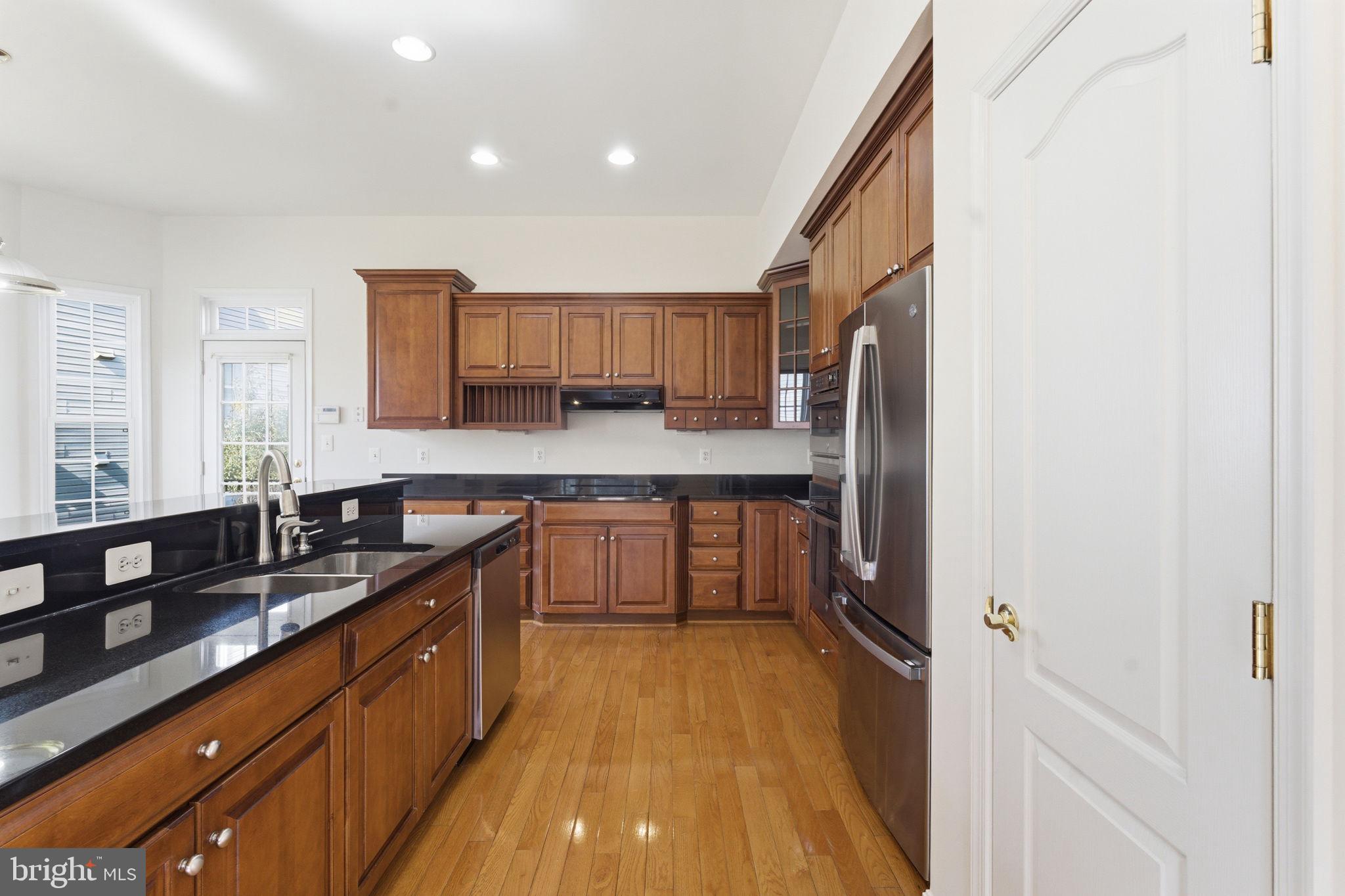 43358 Fullerton Street Ashburn, VA 20147 - Photo 18 of 54 a kitchen with stainless steel appliances granite countertop a sink stove and refrigerator