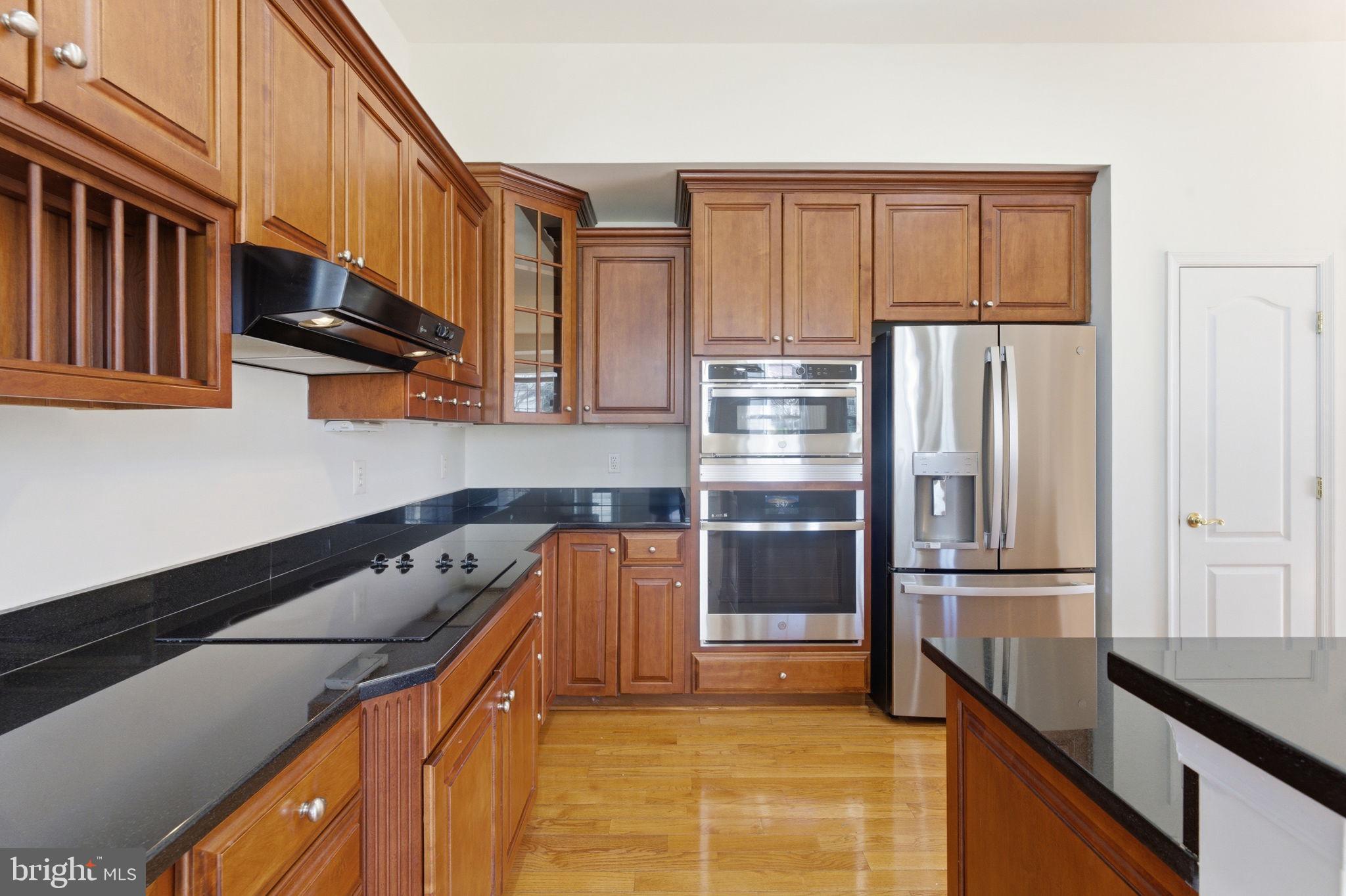 43358 Fullerton Street Ashburn, VA 20147 - Photo 19 of 54 a kitchen with stainless steel appliances granite countertop a refrigerator a stove and a sink