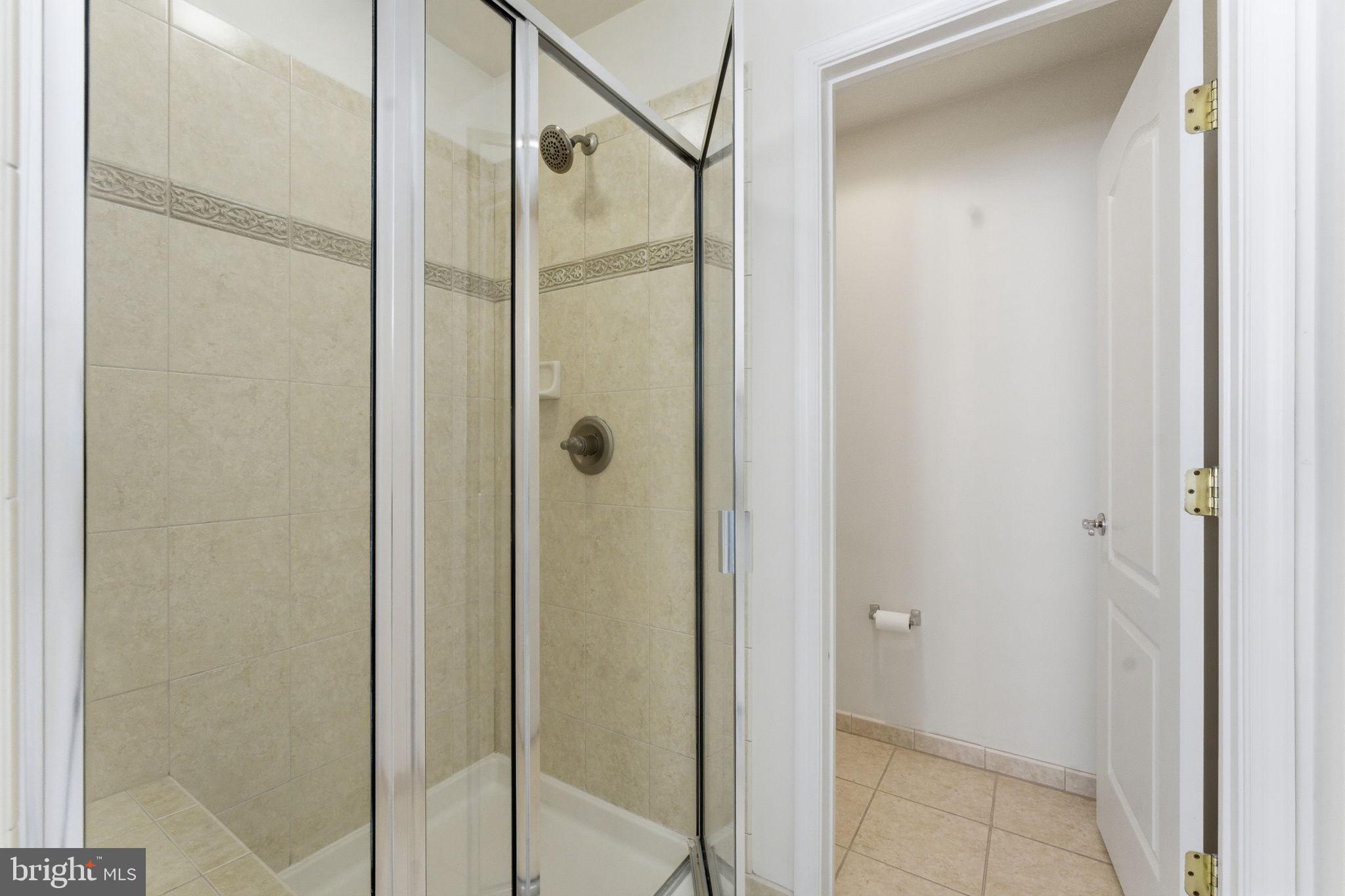 43358 Fullerton Street Ashburn, VA 20147 - Photo 38 of 54 a bathroom with a glass shower door