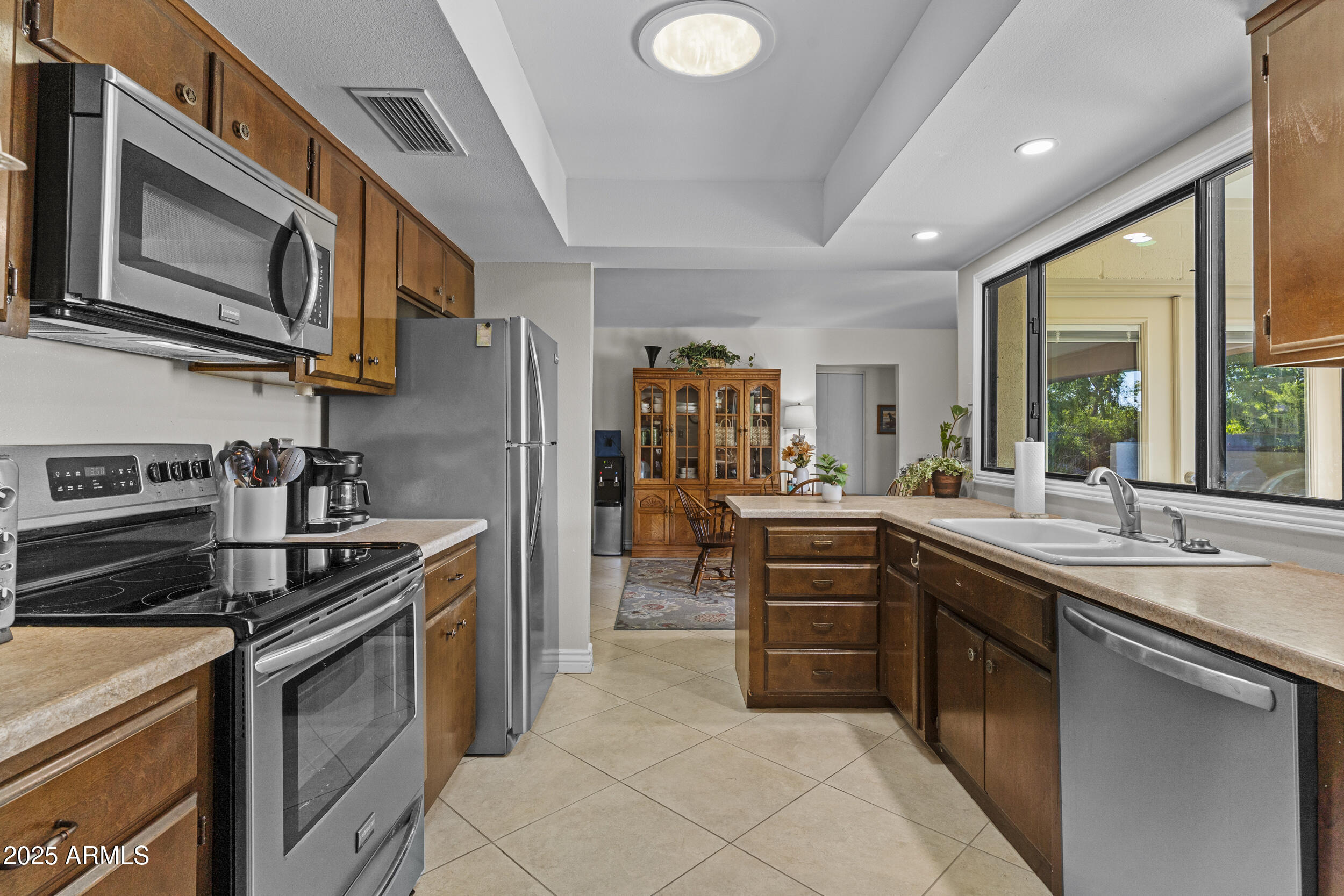 1019 East Watson Drive Tempe, AZ 85283 - Photo 14 of 46 a kitchen with stainless steel appliances granite countertop a sink and stove top oven