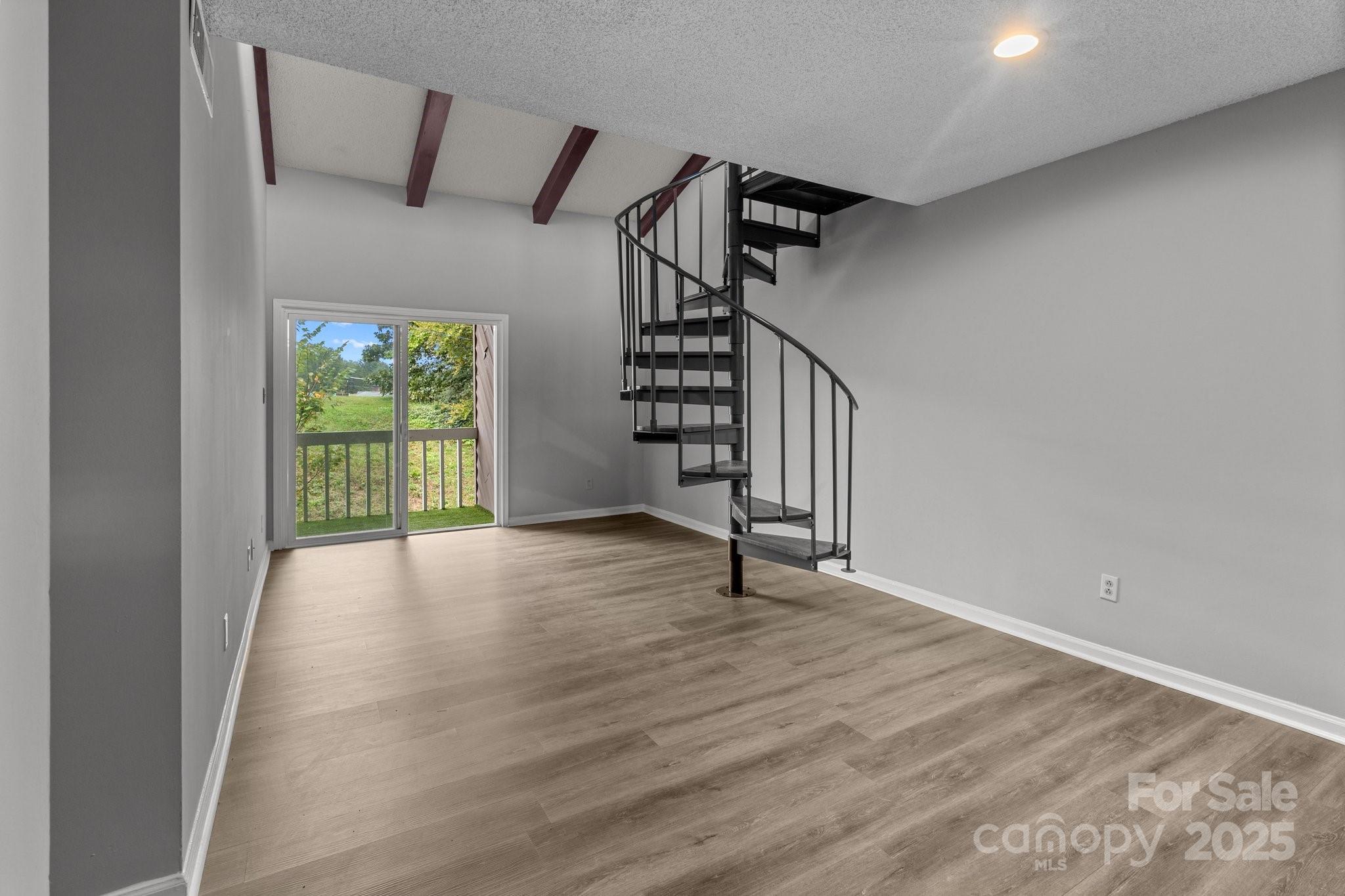 140 Lake Concord Road Northeast, Unit D9 Concord, NC 28025 - Photo 19 of 28 a view of an empty room with wooden floor and stairs