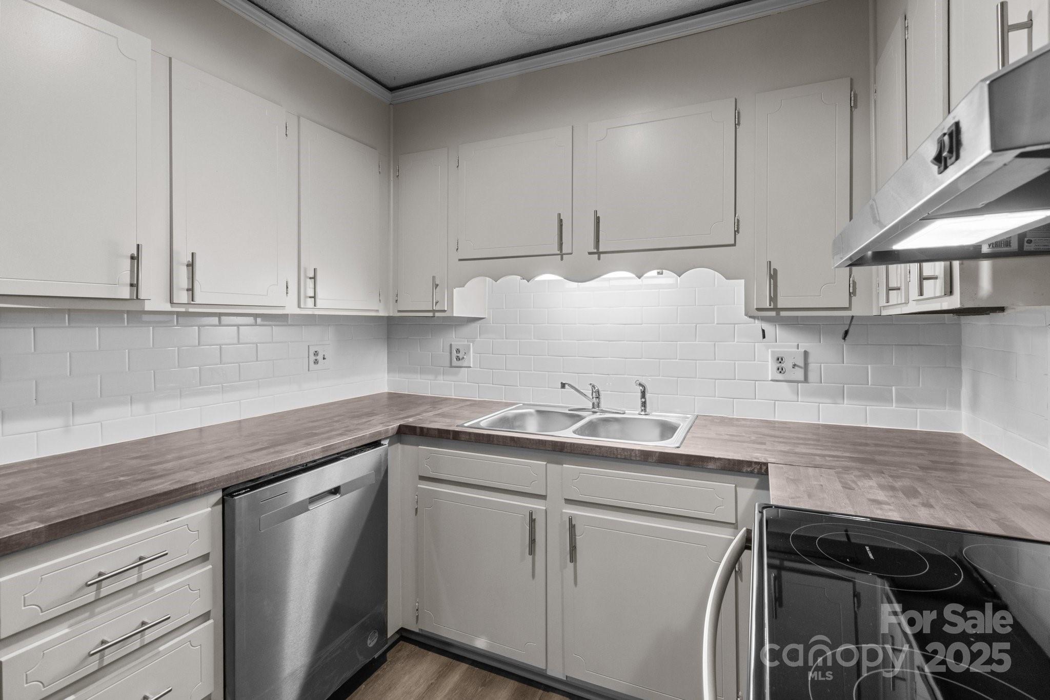 140 Lake Concord Road Northeast, Unit D9 Concord, NC 28025 - Photo 6 of 28 a kitchen with stainless steel appliances granite countertop a sink a stove and cabinets