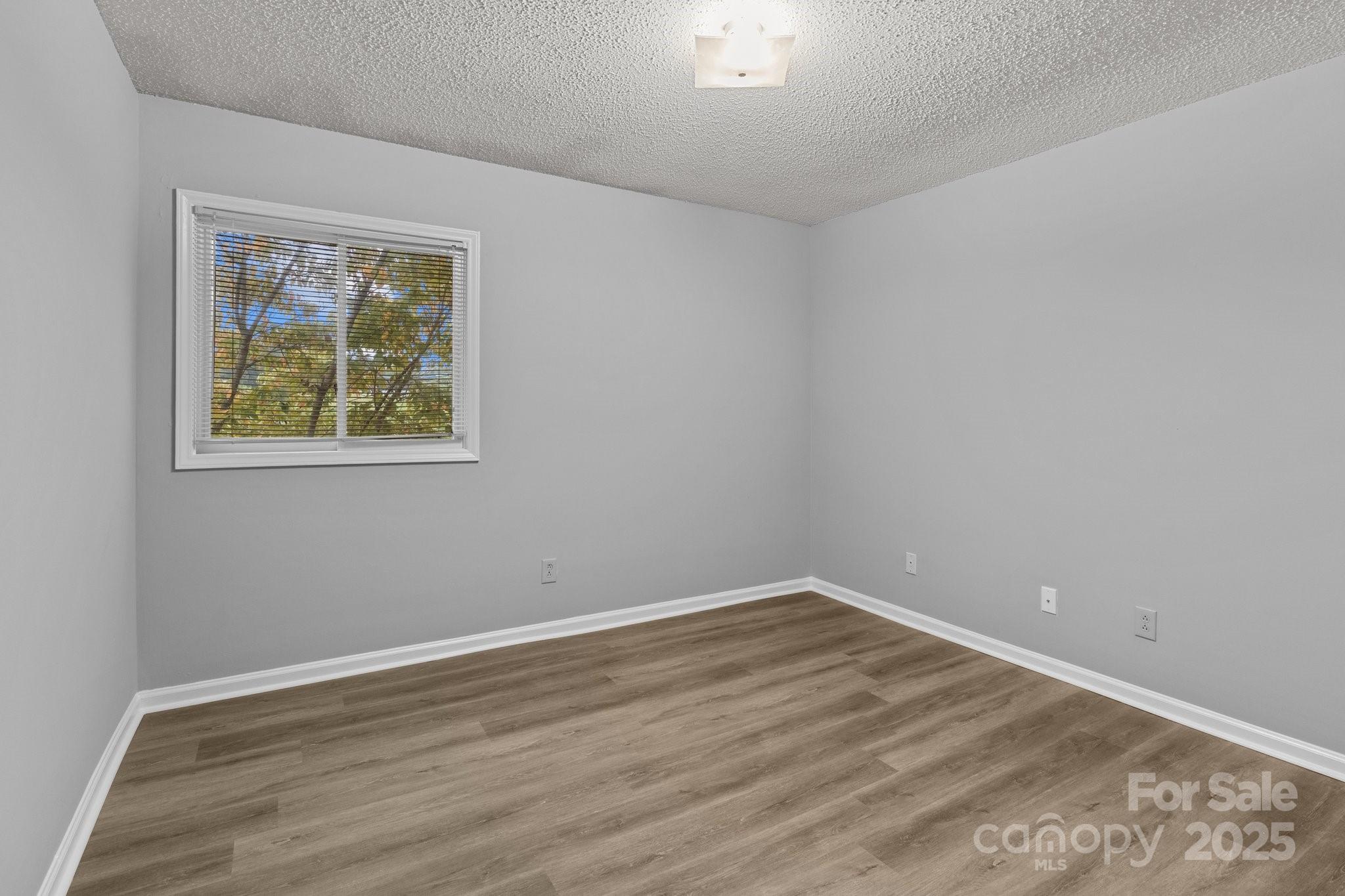 140 Lake Concord Road Northeast, Unit D9 Concord, NC 28025 - Photo 9 of 28 a view of an empty room with wooden floor and a window