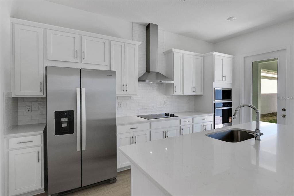13013 Serene Glade Road Winter Garden, FL 34787 - Photo 18 of 57 a kitchen with stainless steel appliances granite countertop a sink a refrigerator and a stove