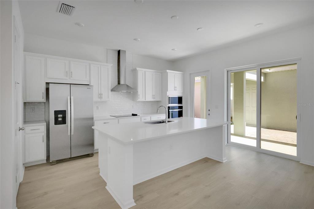 13013 Serene Glade Road Winter Garden, FL 34787 - Photo 19 of 57 a large white kitchen with a refrigerator a sink and a stove top oven