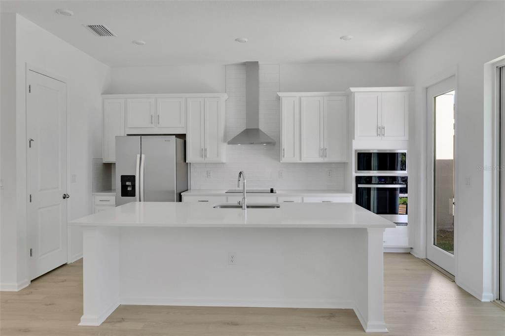 13013 Serene Glade Road Winter Garden, FL 34787 - Photo 20 of 57 a kitchen with stainless steel appliances a refrigerator sink and white cabinets