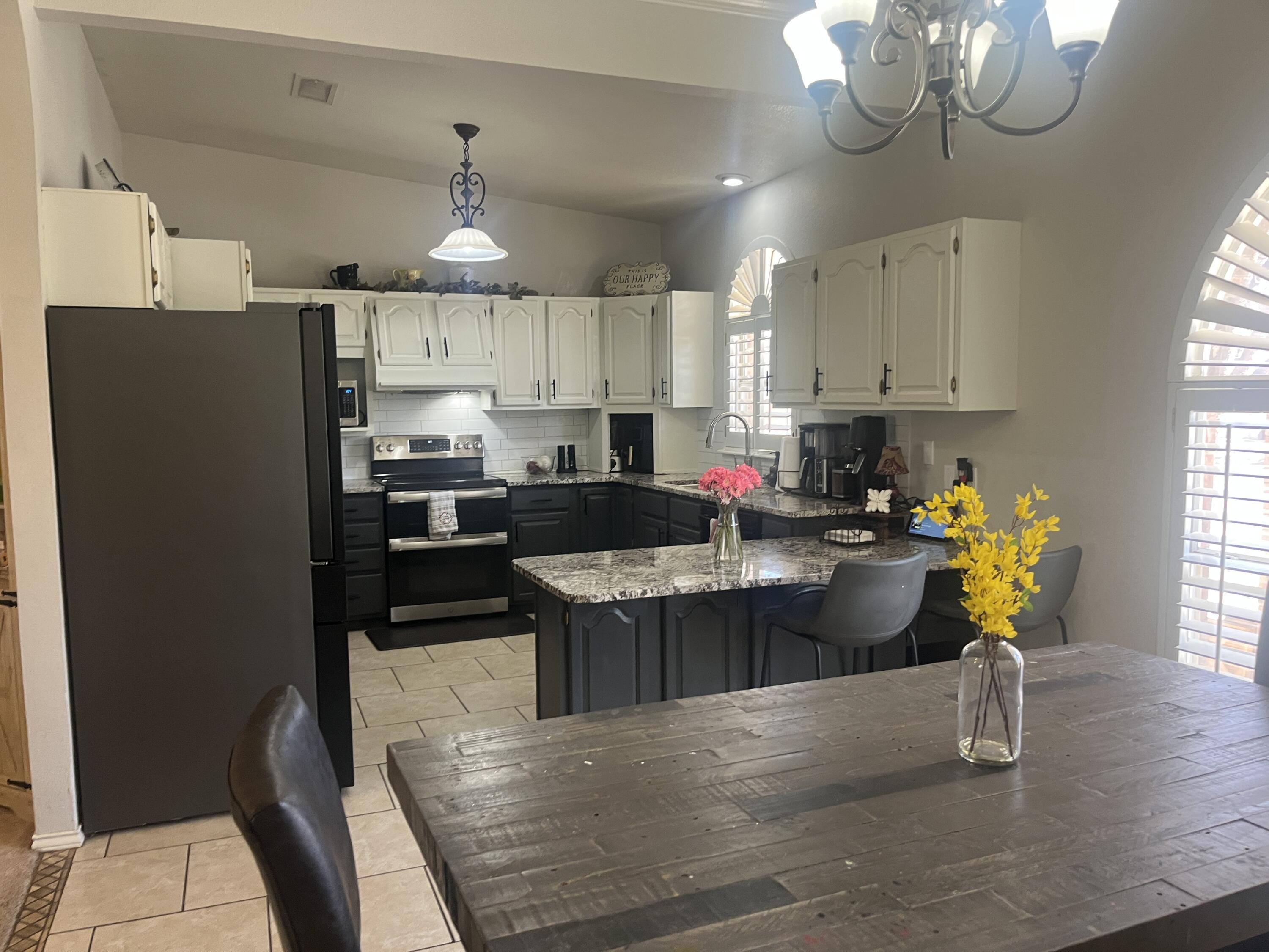2222 South 2nd Place Lamesa, TX 79331 - Photo 13 of 44 a kitchen with a refrigerator a stove a sink dishwasher a dining table and chairs with wooden floor
