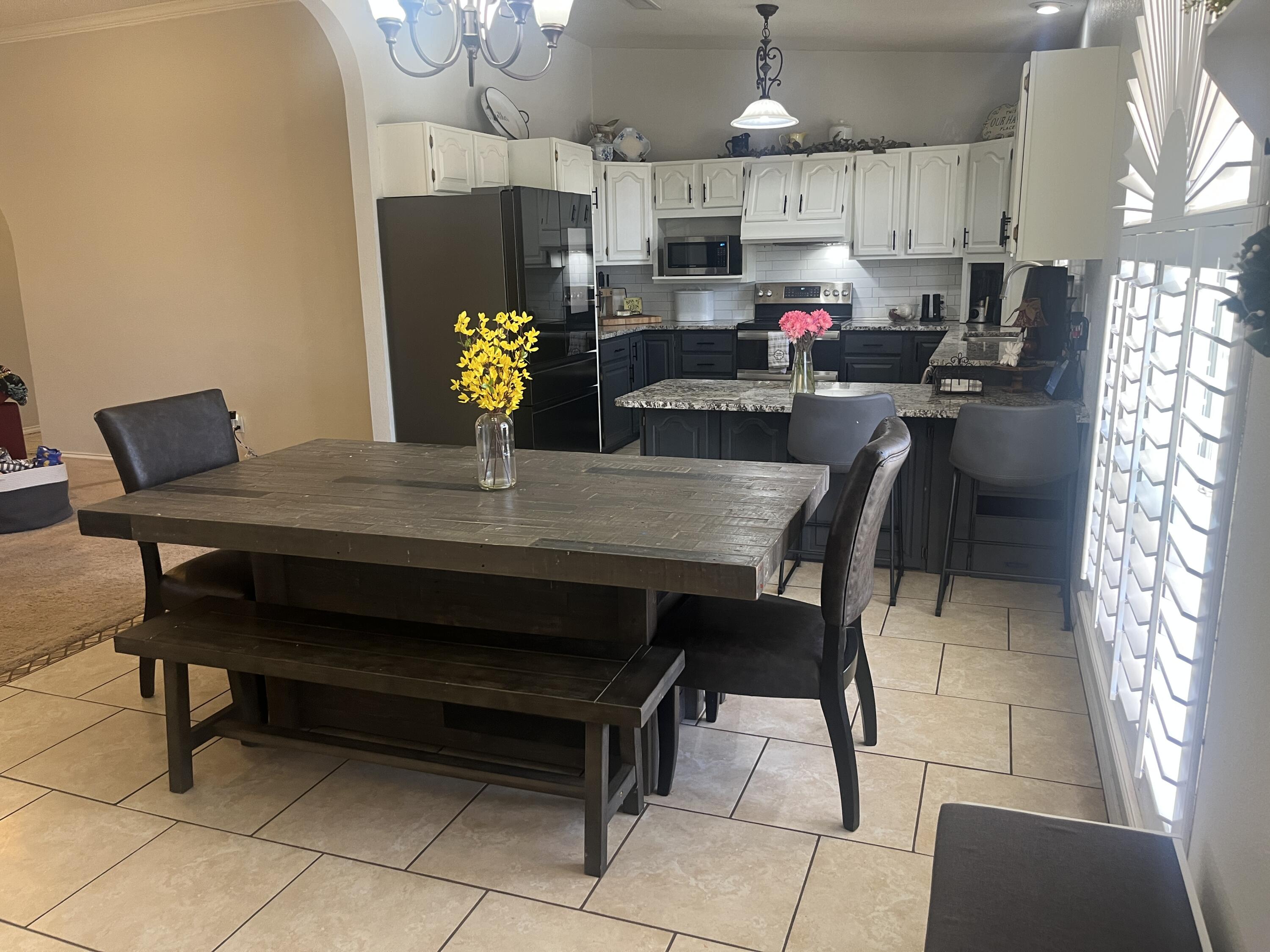 2222 South 2nd Place Lamesa, TX 79331 - Photo 14 of 44 a kitchen with a dining table chairs and refrigerator