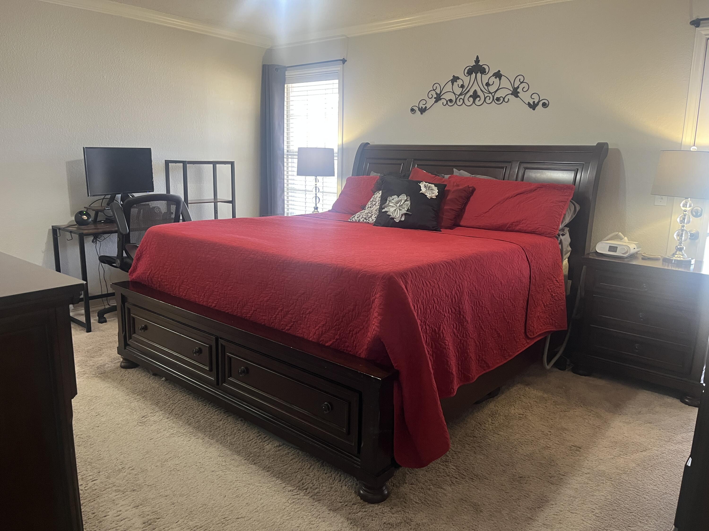 2222 South 2nd Place Lamesa, TX 79331 - Photo 21 of 44 a bed sitting in a bedroom next to a window with a large mirror and a lamp on dresser