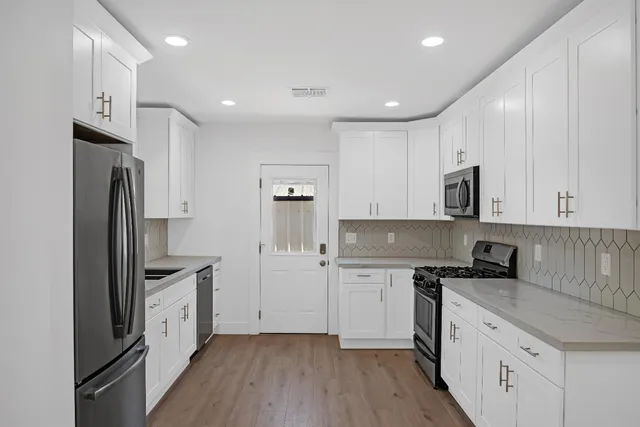 a kitchen with white cabinets and stainless steel appliances
