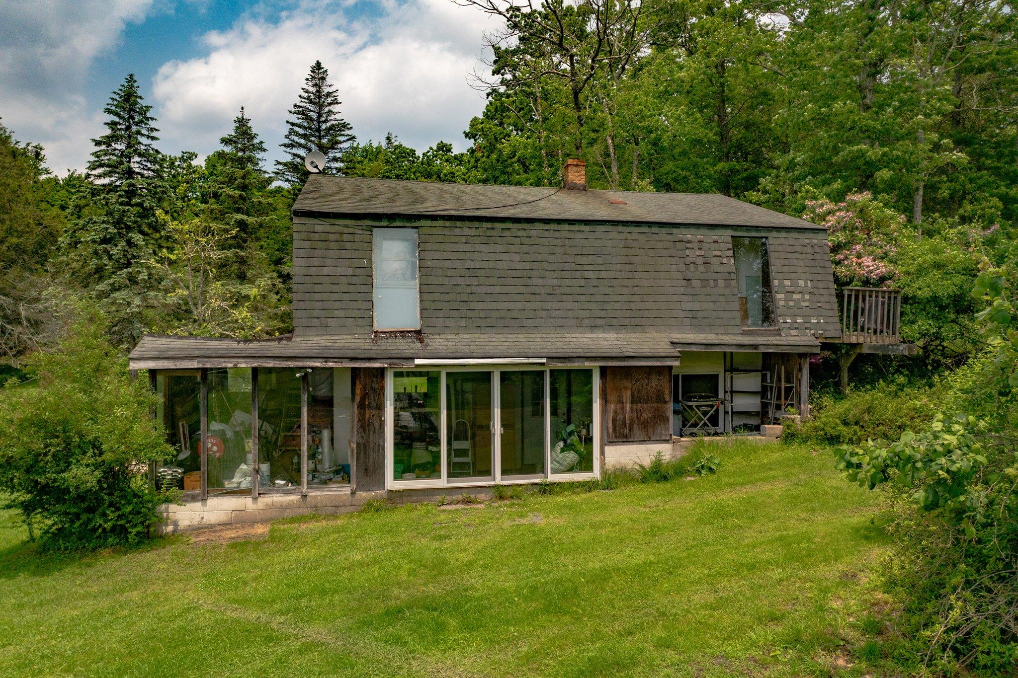 251 Haring Road Barryville, NY 12719 - Photo 17 of 30 Rear view of property featuring a sunroom, a lawn, a gambrel roof, a chimney, and roof with shingles