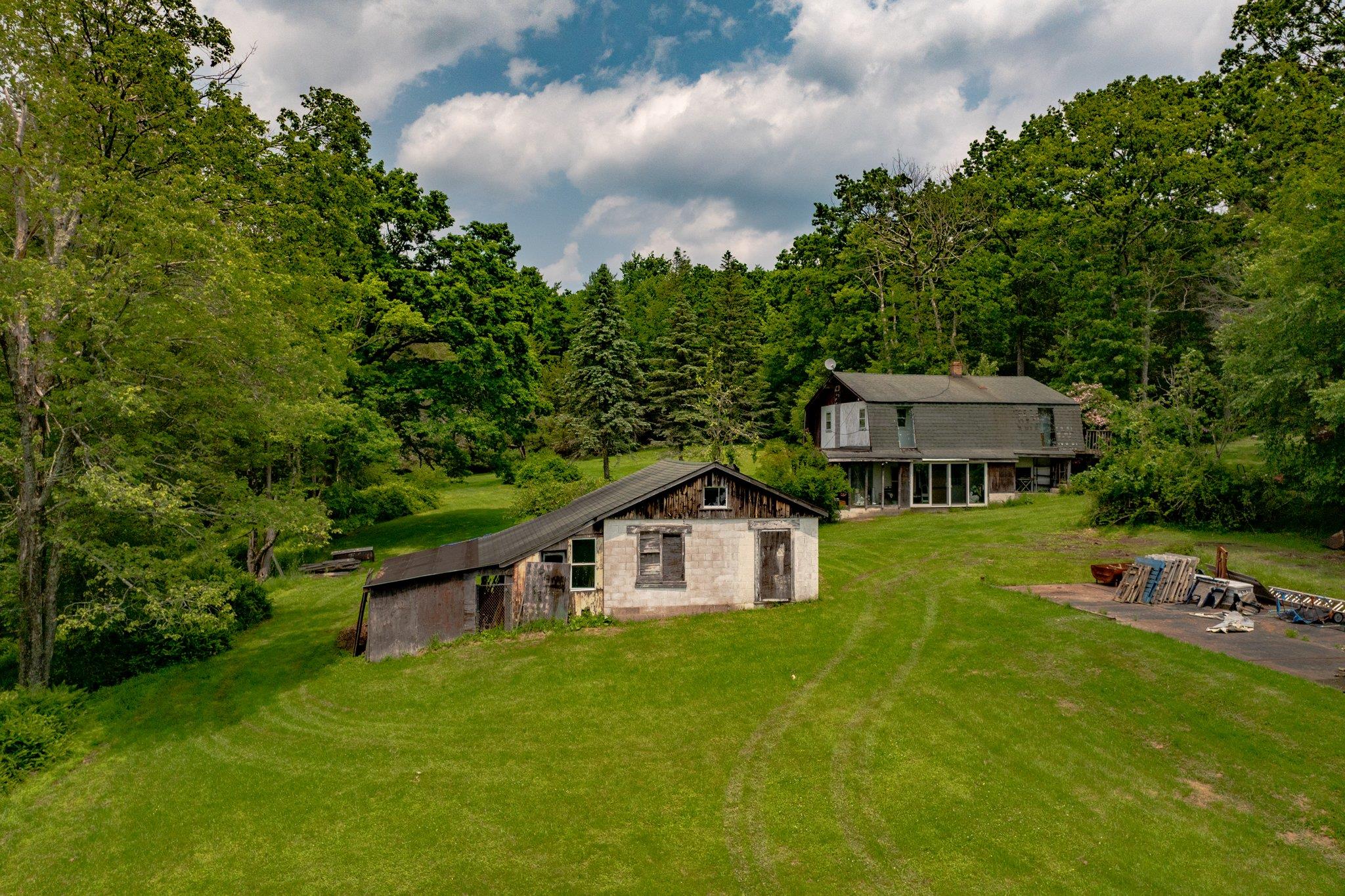 251 Haring Road Barryville, NY 12719 - Photo 19 of 30 Rear view of house featuring a lawn, stone siding, a patio, and a view of trees