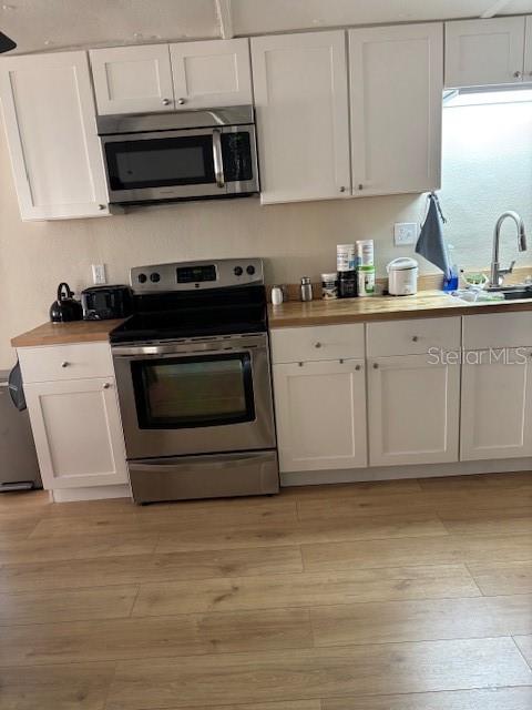 9145 Rally Lane Holiday, FL 34690 - Photo 11 of 14 a kitchen with stainless steel appliances granite countertop a stove a sink and a microwave