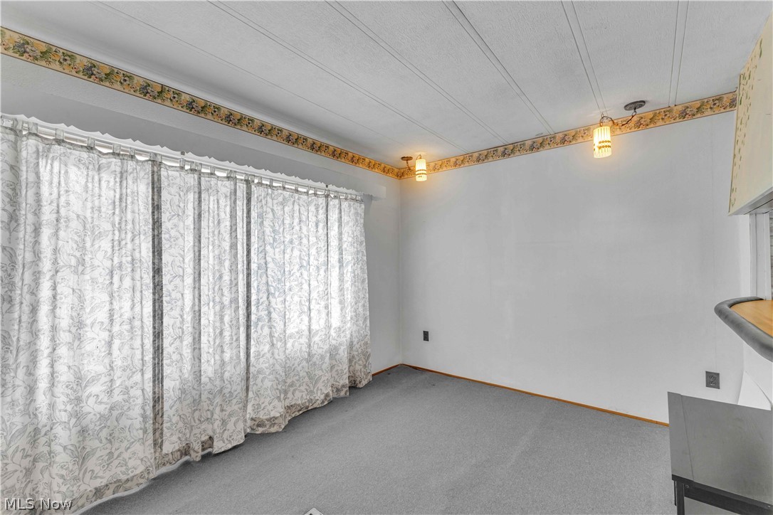 6610 Lear Nagle Road, Unit 154 North Ridgeville, OH 44039 - Photo 6 of 26 Unfurnished dining area featuring carpet and a textured ceiling