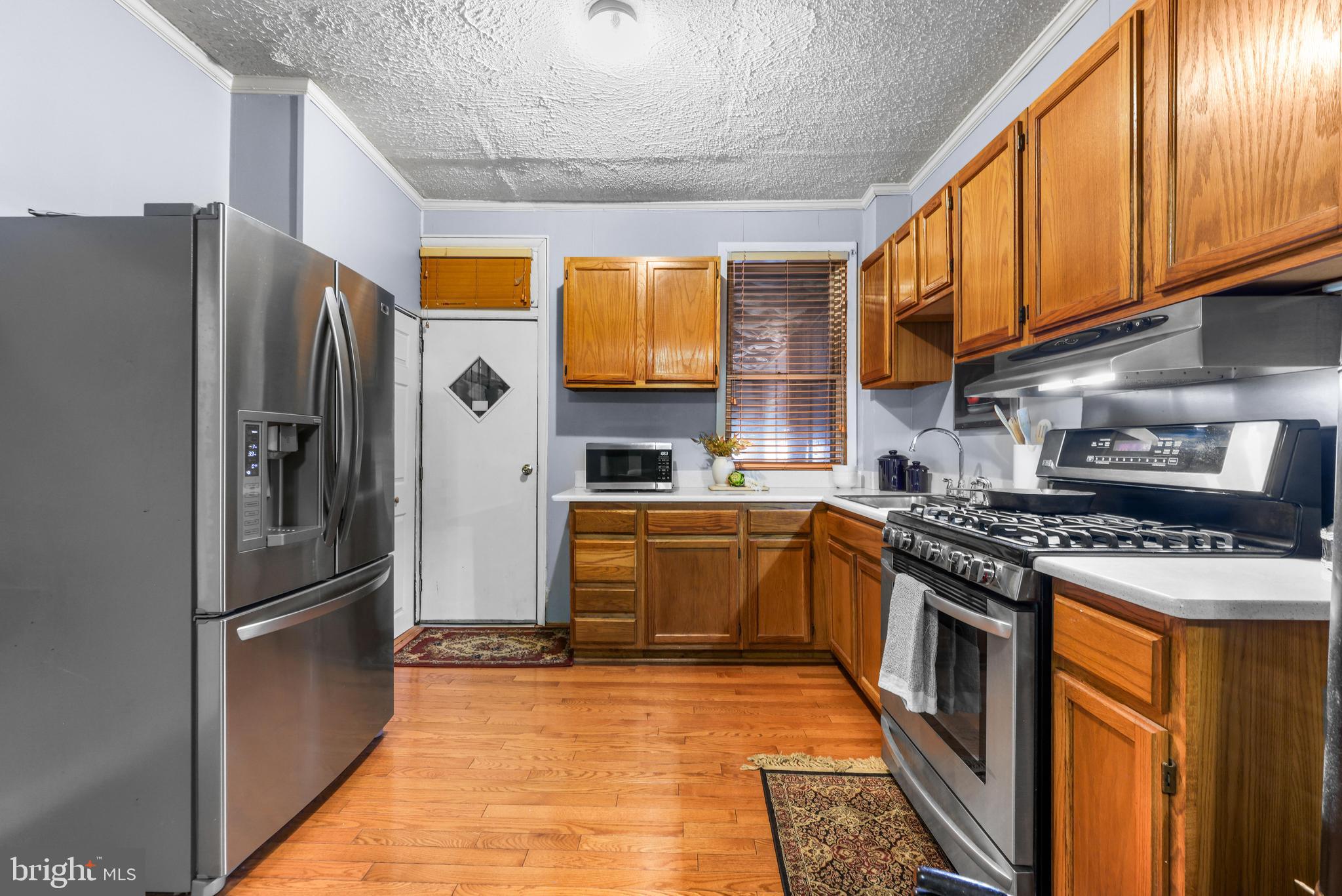 1113 South Robinson Street Baltimore, MD 21224 - Photo 12 of 38 a kitchen with stainless steel appliances granite countertop a refrigerator a stove and a sink