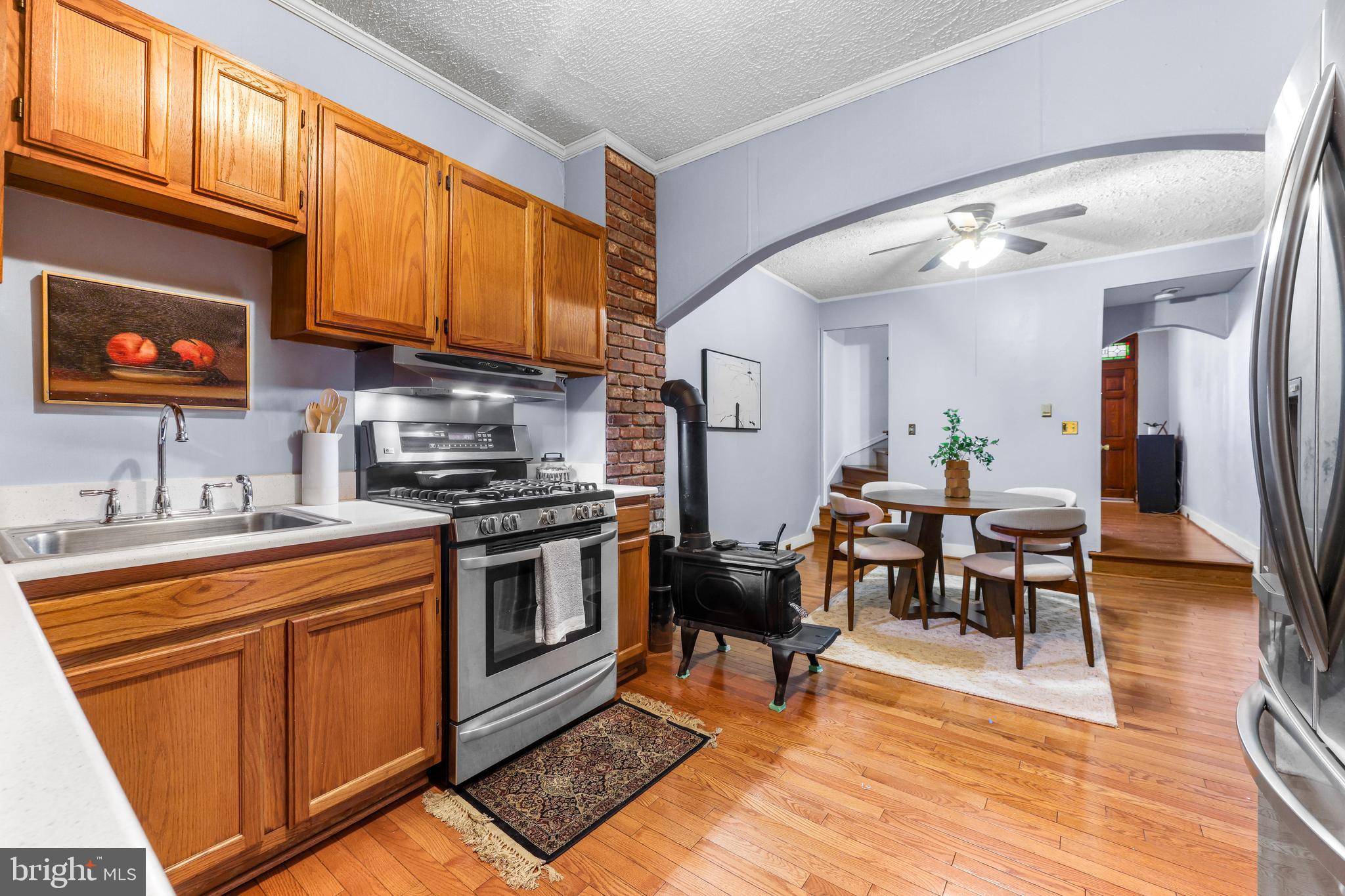 1113 South Robinson Street Baltimore, MD 21224 - Photo 14 of 38 a kitchen with stainless steel appliances granite countertop a stove top oven a sink dishwasher and cabinets with wooden floor