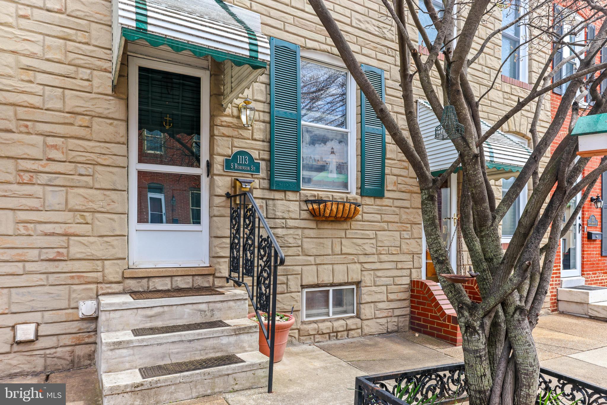 1113 South Robinson Street Baltimore, MD 21224 - Photo 3 of 38 a front view of a house with a tree