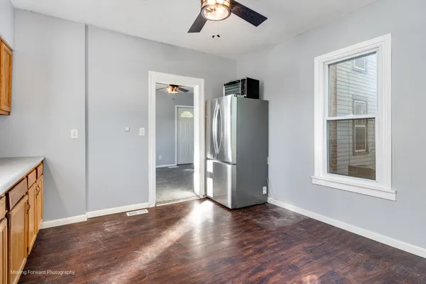 a view of an empty room with a window and wooden floor