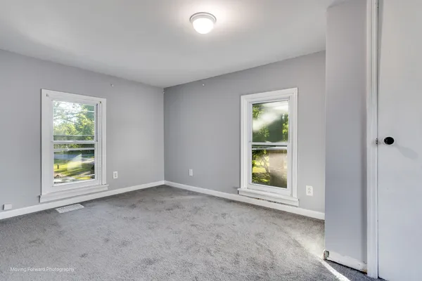 an empty room with windows and closet