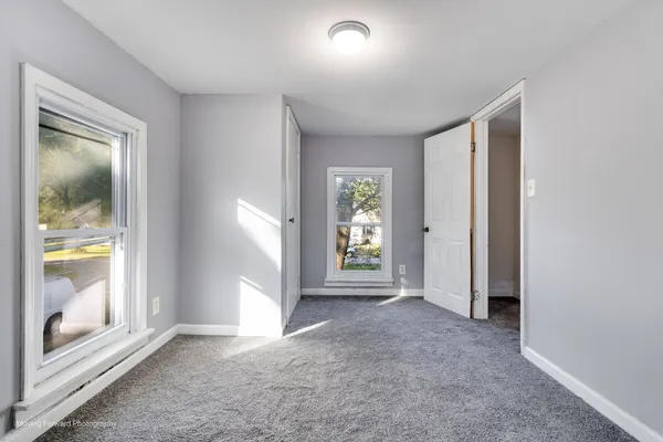 an empty room with windows and mirror