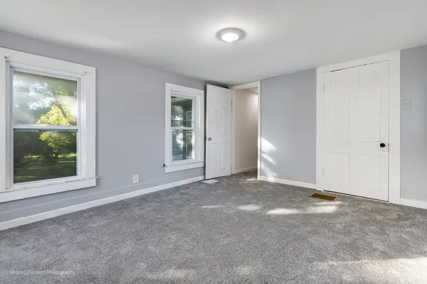 a view of an empty room with glass door and a window
