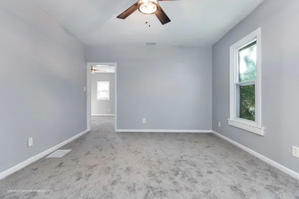 an empty room with windows and closet